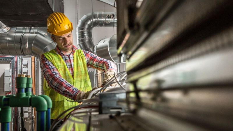 Ein Handwerker arbeitet an einer Klimaanlage