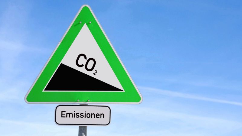Verkehrsschild mit CO2-Beschriftung auf einer abfallenden Wegstrecke