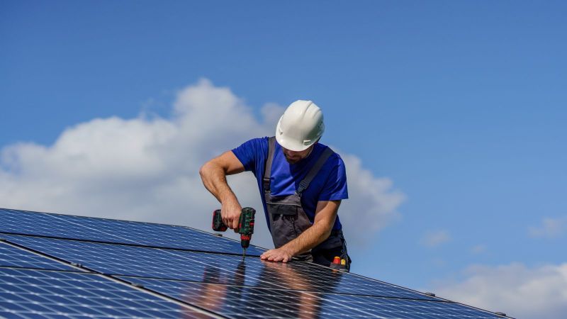 Symbolbild: Handwerker installiert Photovoltaikmodule.