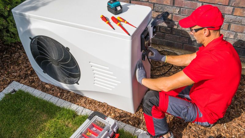 Ein Handwerker arbeitet an einer Wärmepumpe.