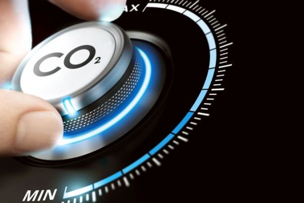 CO2-Emissionen reduzieren Hand dreht Knopf mit Aufschrift CO2 nach unten