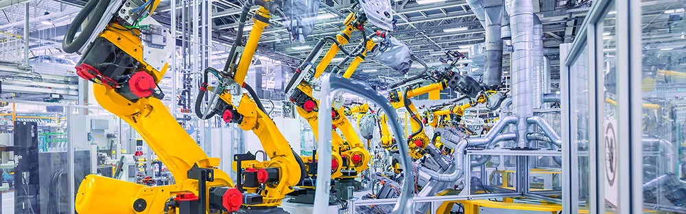 Yellow roboter arms manufacturing car parts. 