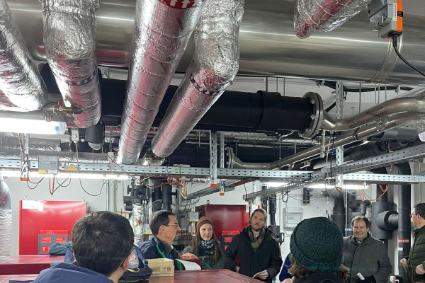 Personen in der Heizentrale der Postsiedlung